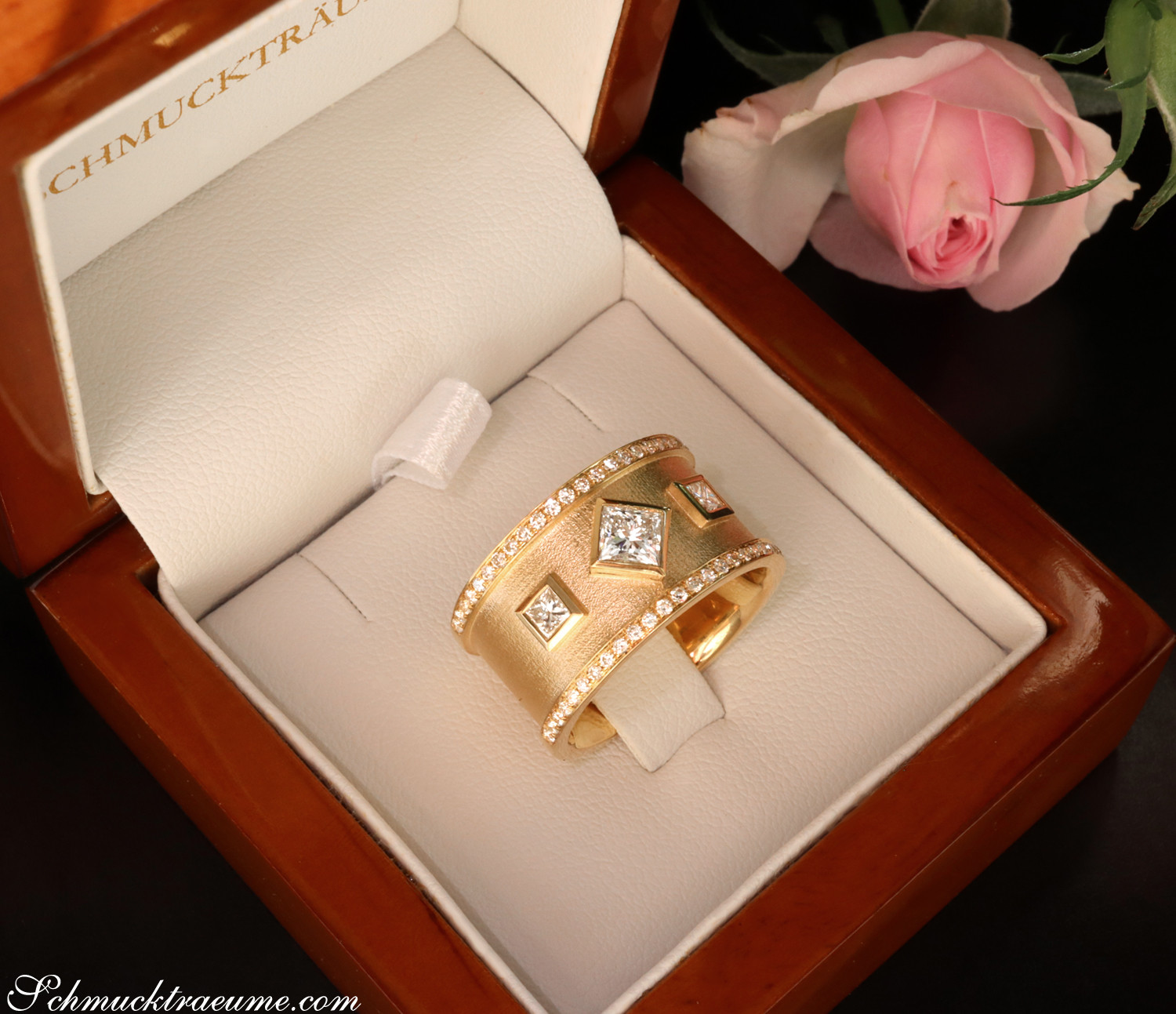 Goldener Ring mit Diamanten in Box, Rosen im Hintergrund