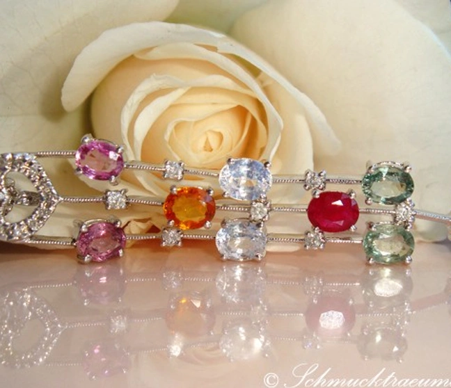 Edelsteinanhänger mit funkelnden Steinen auf Kette, Rosenblüte im Hintergrund Edelsteinanhänger mit funkelnden Steinen auf Kette, Rosenblüte im Hintergrund