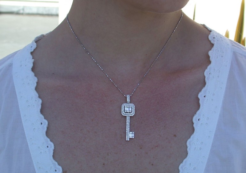 Detailansicht von Weißgold-Schlüssel-Anhänger mit Baguette-Diamanten, getragen auf weißem Oberteil