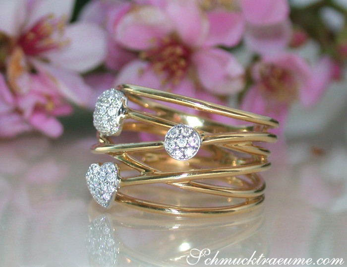 Rosenblüten umgeben goldfarbenen Diamantring mit Herz- und Kreisformen