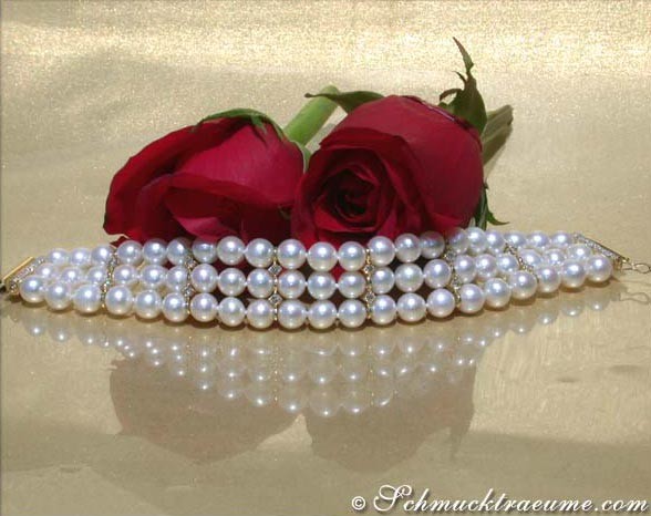 Dreireihiges Süßwasserperlen Armband in Gelbgold 585, Rosen im Hintergrund, glänzende Oberfläche