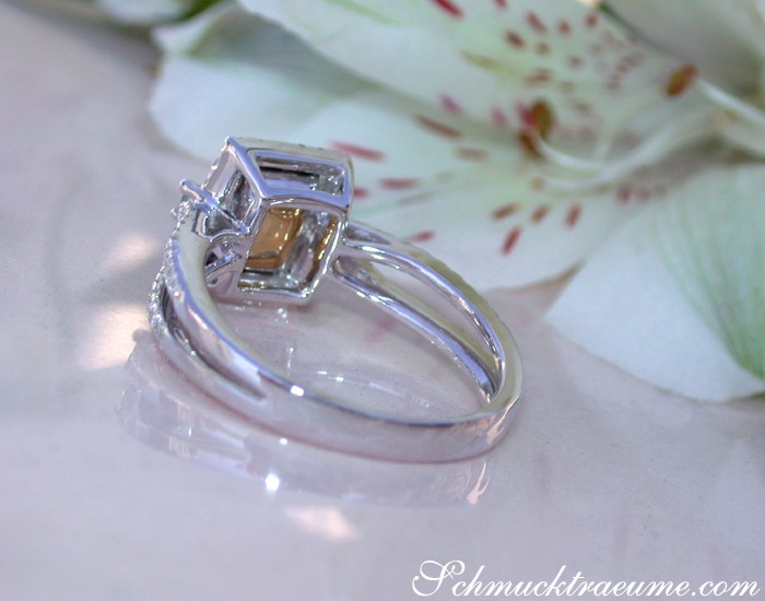 Klassischer Smaragd-Ring mit Brillanten auf Blütenhintergrund