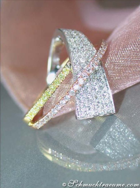 Detailansicht des feinen Brillantenrings mit gelben Diamanten, gehalten auf rosa Seide