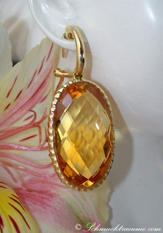 Goldener Citrin-Ohrhänger mit klaren Facetten, detailreich, auf Blume präsentiert