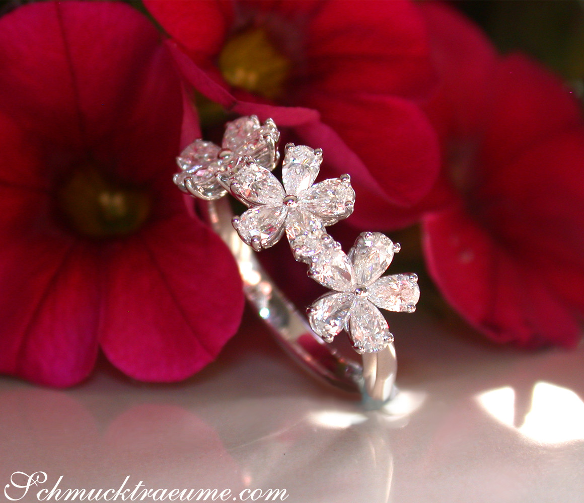 Diamantblüten-Ring in Weißgold, fünfzehn Diamanten, Blütenform, auf rotem Blütenhintergrund