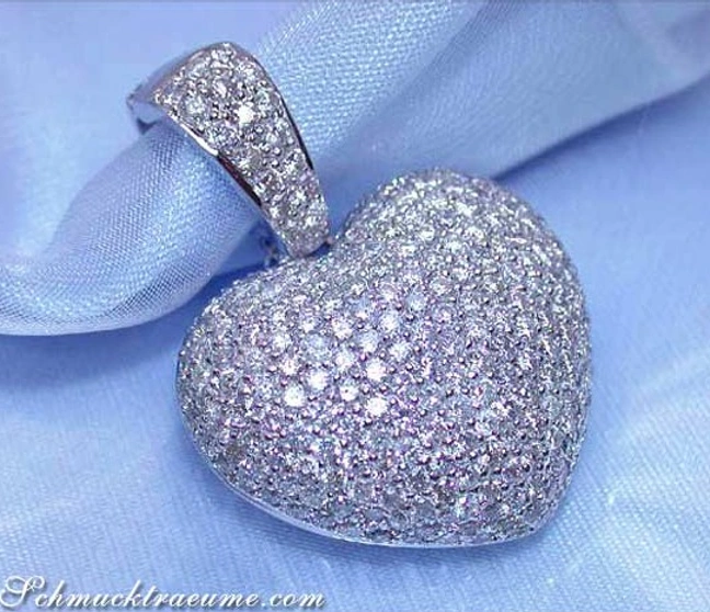 Edler Herz-Anhänger mit Diamanten auf weißem Gewebe, Detailaufnahme. Edler Herz-Anhänger mit Diamanten auf weißem Gewebe, Detailaufnahme.