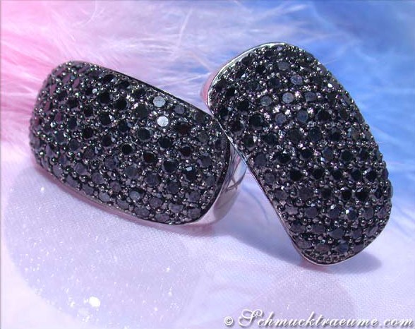 Schwarzgoldene Diamant-Ohrstecker mit glitzernden Steinen, detailreich, auf Federhintergrund.