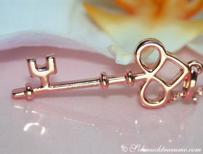 Rosenkristallhintergrund, Detail des Diamanten Schlüssel Anhängers in Roségold