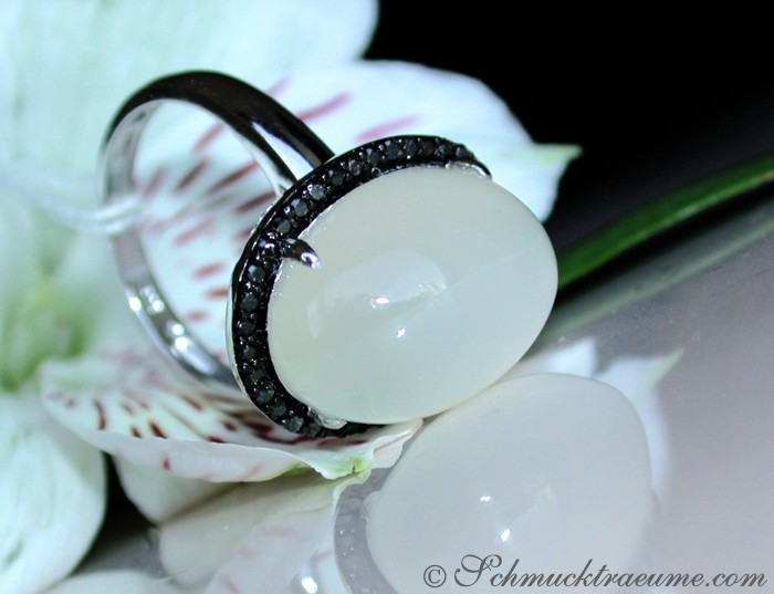 Silbergrauer Mondstein-Ring mit schwarzen Diamanten auf Orchideenblüte