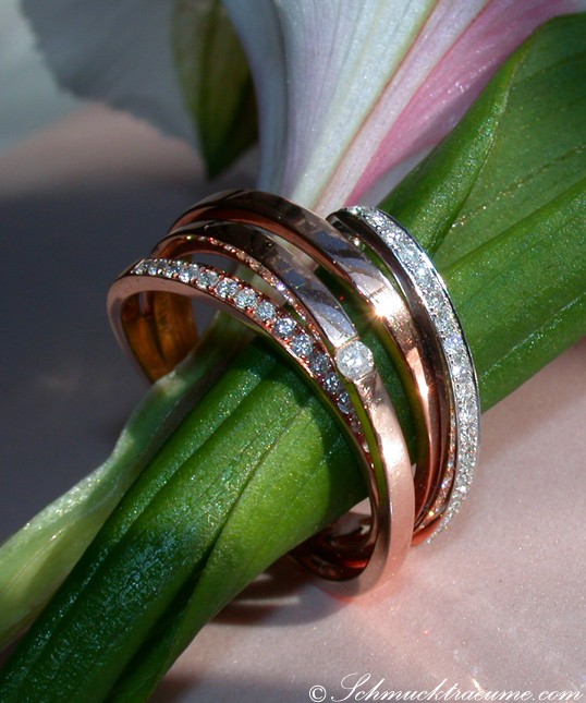 Detailansicht von Diamantringen in Weißgold und Roségold auf Blütenblatt