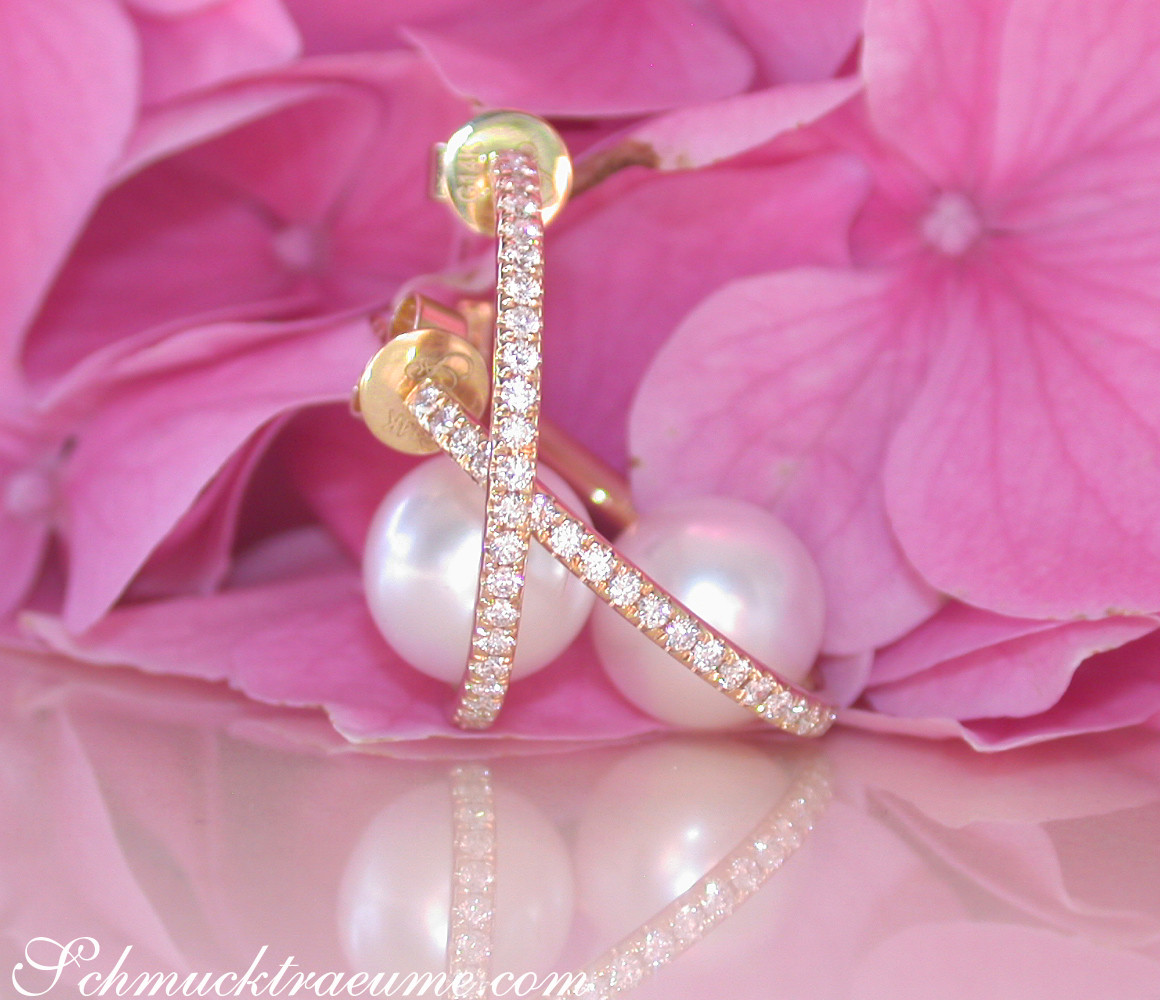 Kreuzförmige Creolen mit Diamanten und Perle, auf rosa Blüte