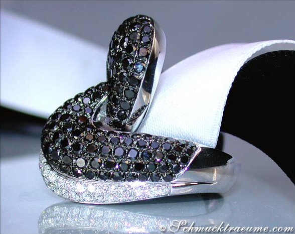 Schwarz-diamantierte Ringdetail auf weißem Stoff, elegant und glänzend.