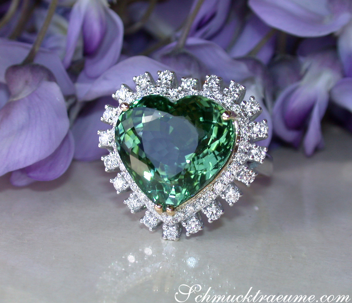 Herzform Turmalin-Ring mit Brillanten in Weißgold, umgeben von Blumenblättern.
