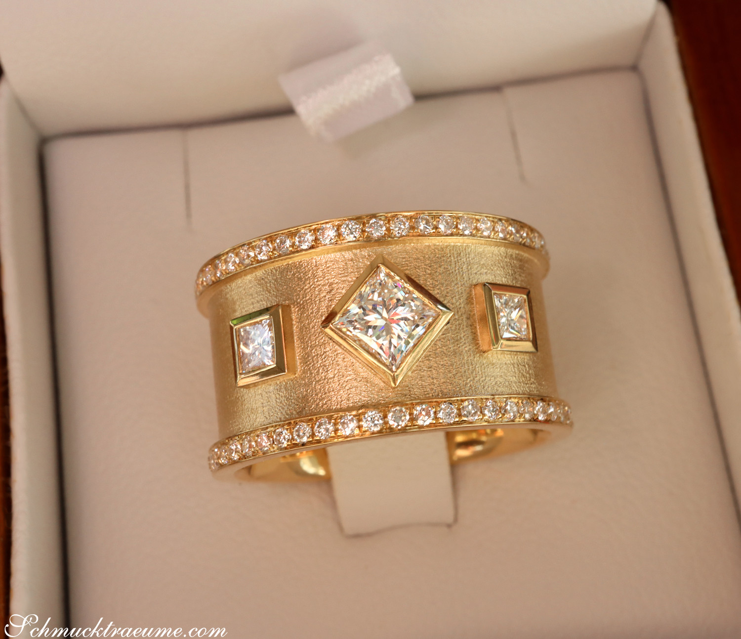 Goldener Ring mit Diamanten in Princess-Schliff, detailreich, elegant in Box.