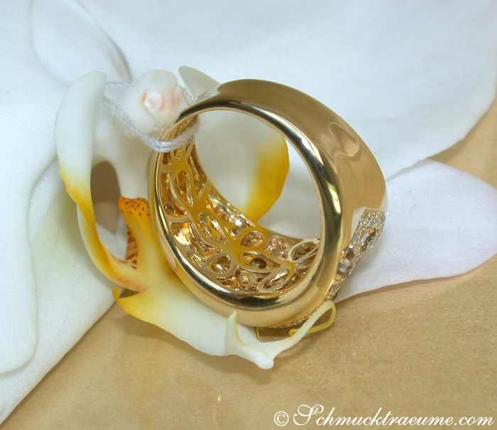 Goldener Ring mit weiß-braunen Brillanten, Detailaufnahme auf Orchidee, elegant und luxuriös.