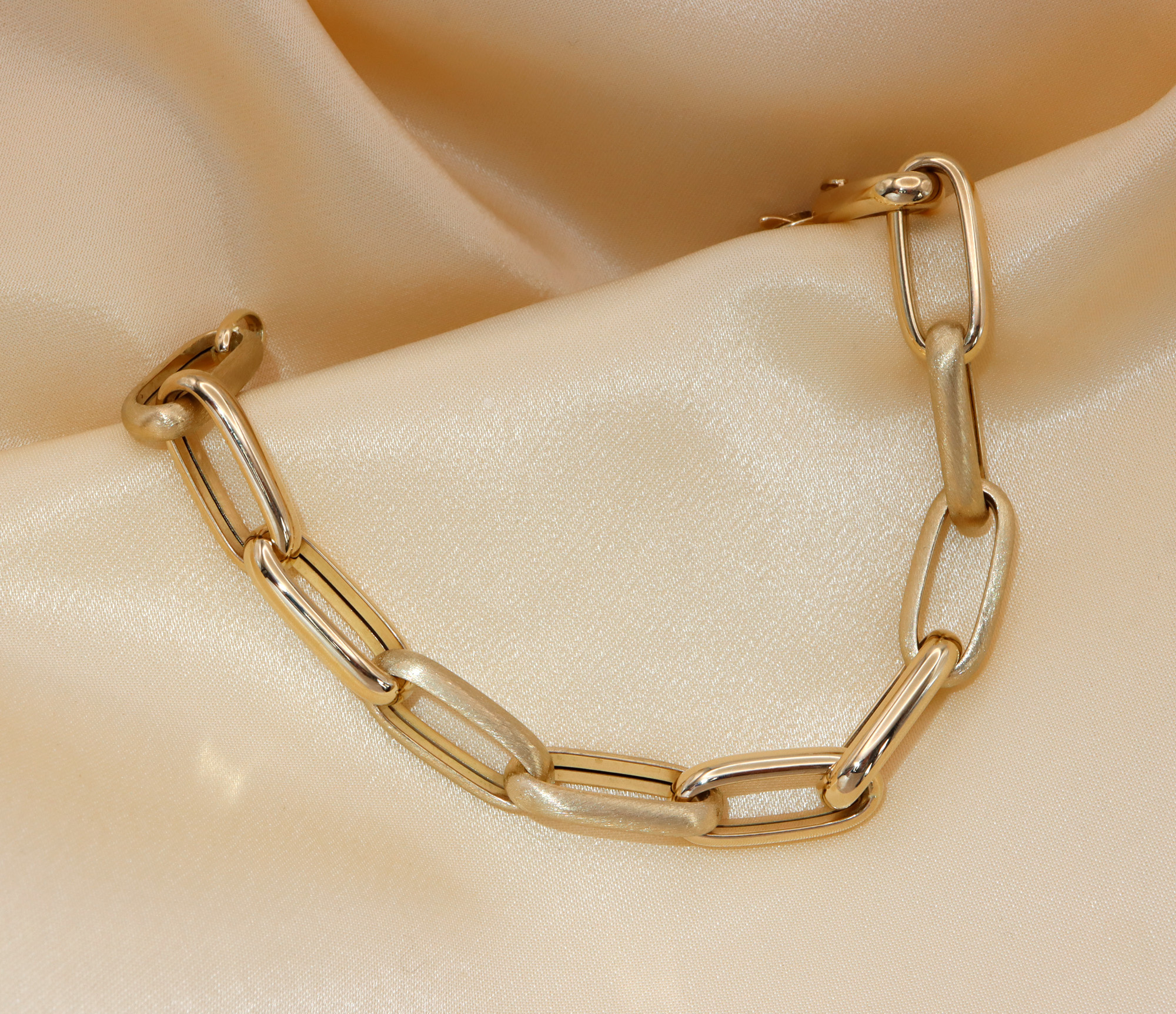 Goldarmband aus 585er Gelbgold, satiniert & glänzend, Detailaufnahme auf seidigem Hintergrund