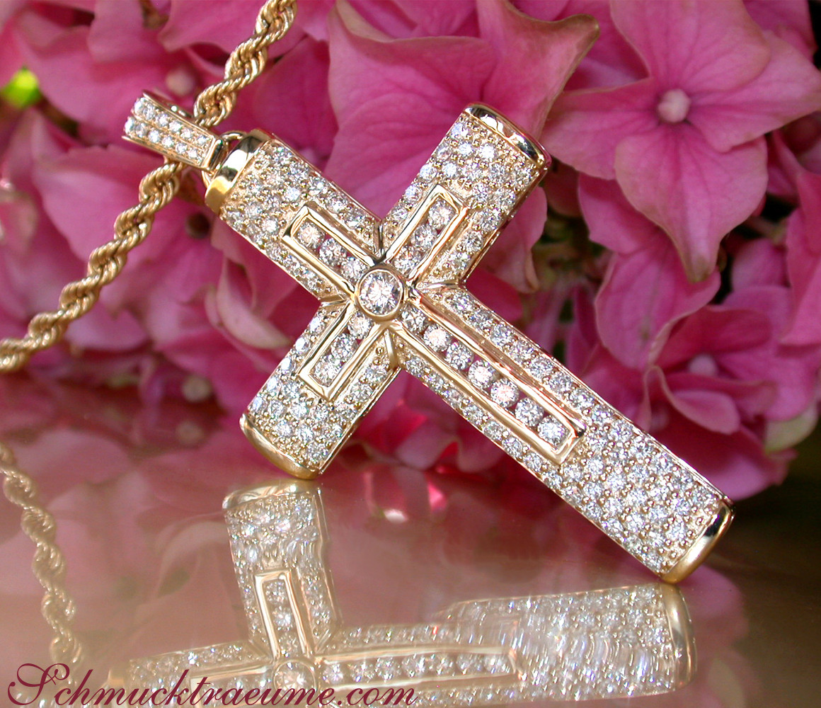 Gelbgold 750 Kreuzanhänger mit Diamanten, Detailaufnahme vor rosa Hortensienblüten.