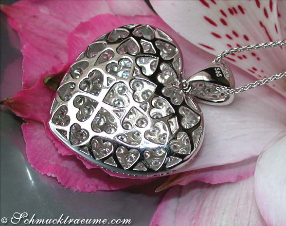 Detailansicht des Brillanten Herz Anhängers in Weißgold, umgeben von Rosenblättern