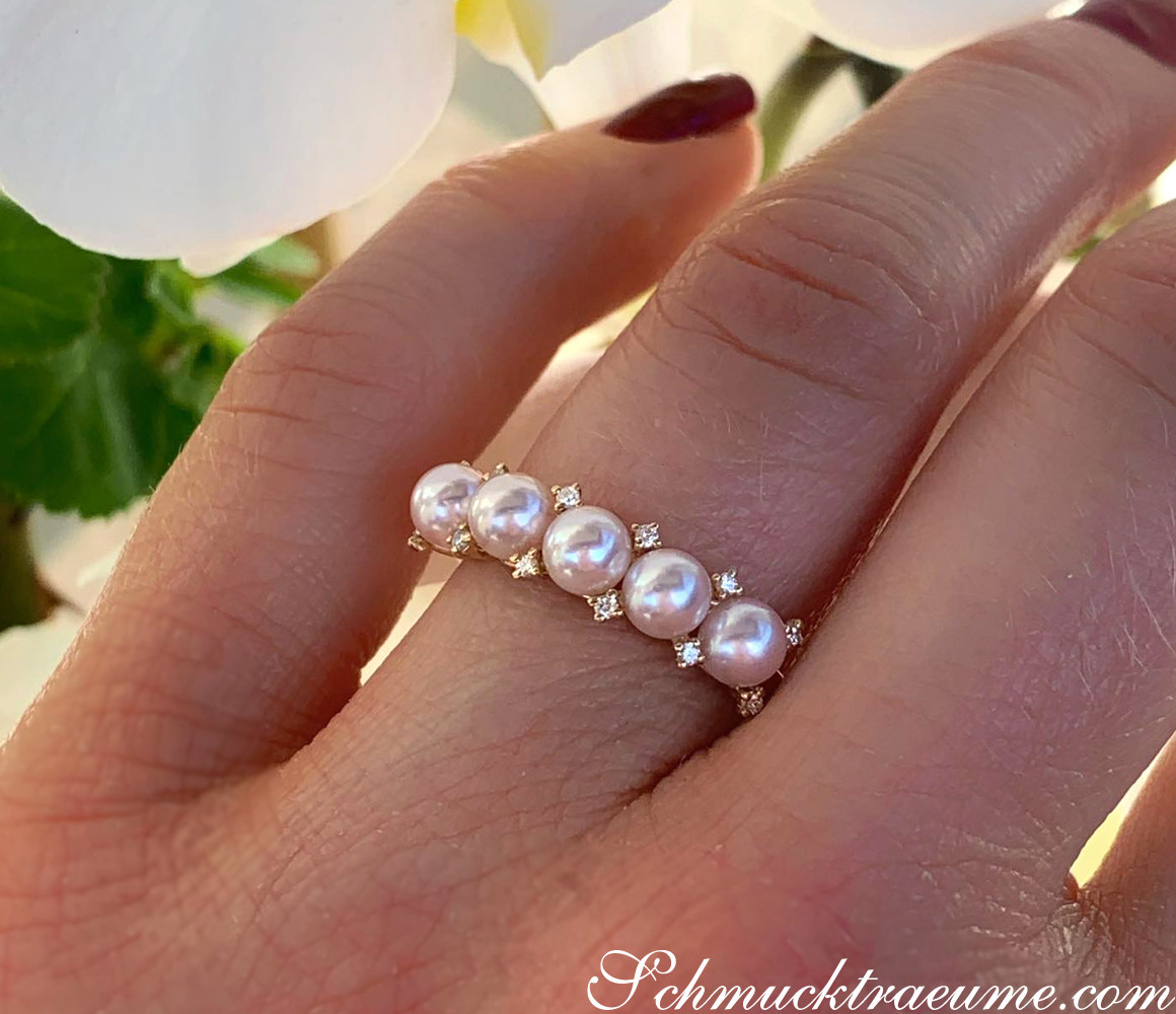 Perlenring mit 9 Akoya-Perlen und Diamanten, Gelbgold 585, Detailaufnahme auf der Hand.