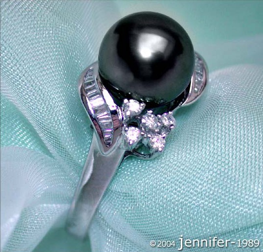 Detailansicht von Tahitiperle-Ring in Weißgold, 9-10 mm, 0.470 Karat, auf blauem Stoff liegend.