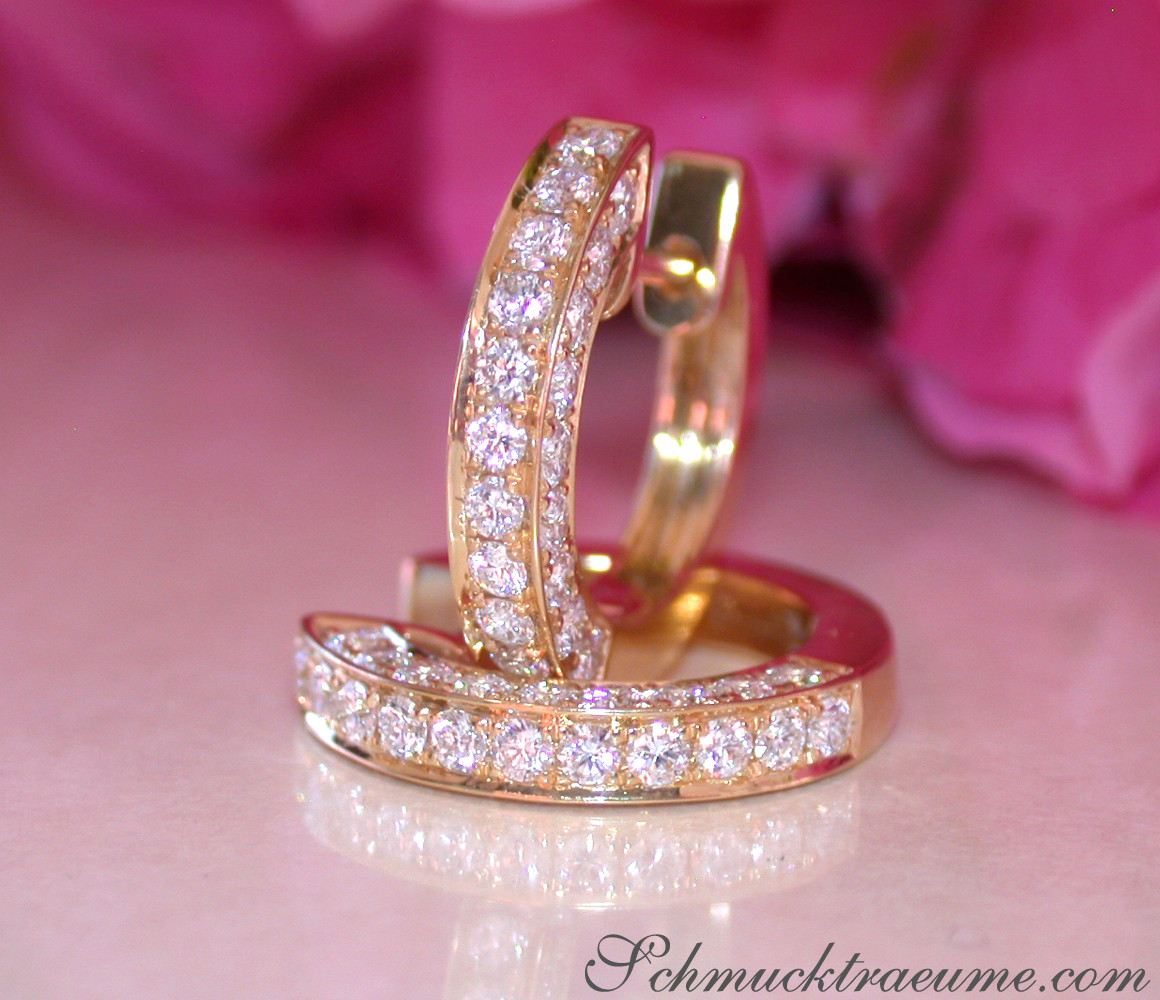 Gelbgold Kreisohrringe mit Brillanten, detailreich, elegant, rosa Hintergrund.