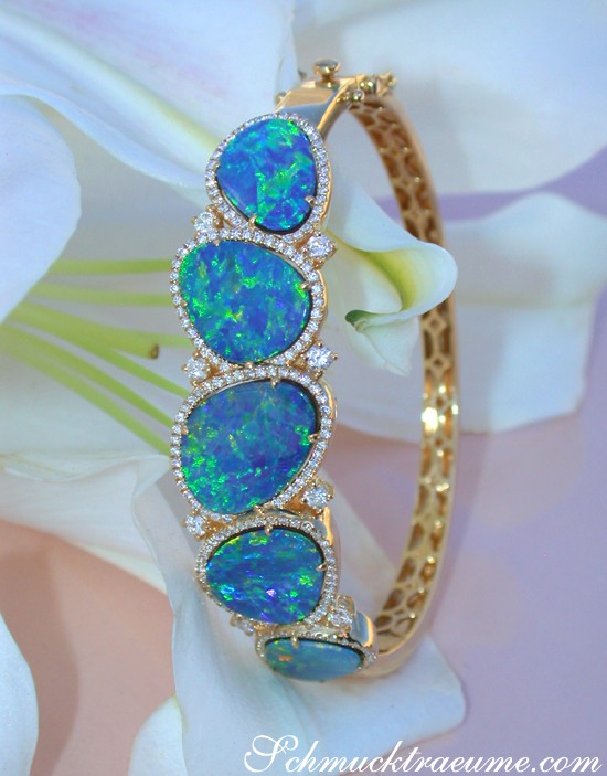 Goldener Boulder Opal Armreif mit Brillanten, Detailaufnahme auf weißem Blütenhintergrund