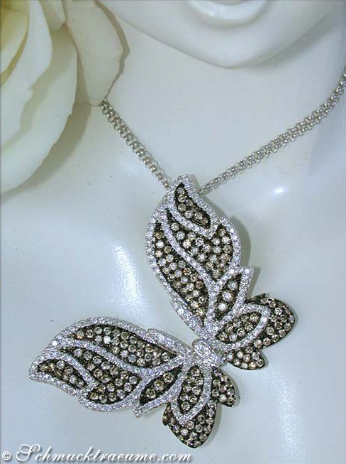 Schmetterling-Anhänger mit braunen und weißen Brillanten, Detailaufnahme, getragen auf Puppenkopf.