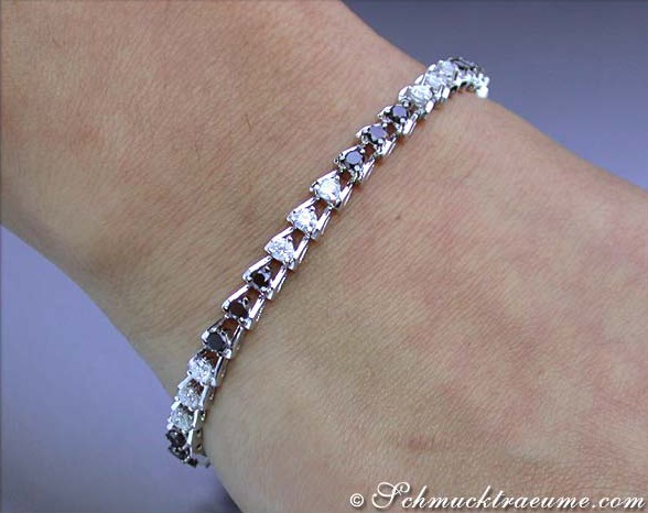 Weißgold-Armband mit schwarzen & weißen Diamanten auf Hand.