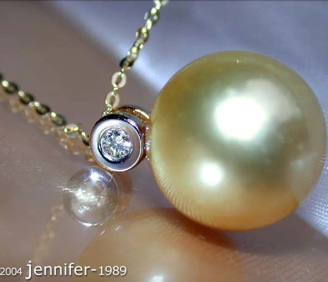 Klassischer goldener Südseeperlen-Anhänger mit Brillant, Detailaufnahme, getragen Klassischer goldener Südseeperlen-Anhänger mit Brillant, Detailaufnahme, getragen