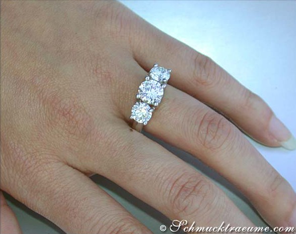 Glänzender Diamant-Ring mit drei Solitären auf Handgelenk