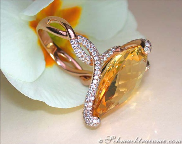 Detailaufnahme des Citrin-Rings mit Roségold und Diamanten, liegt auf Blume.