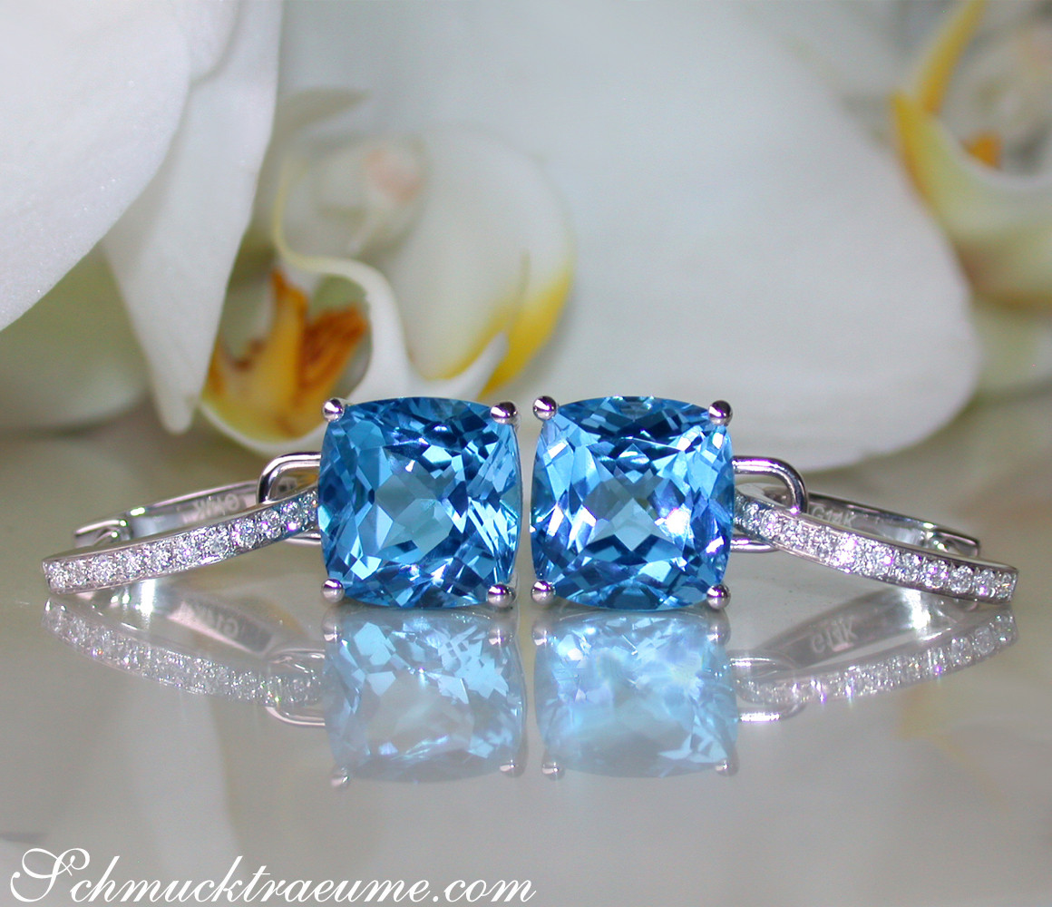 Blautopas-Kissen-Ohrringe mit Diamanten, detailreich, elegant, weißgold, Orchidee im Hintergrund.