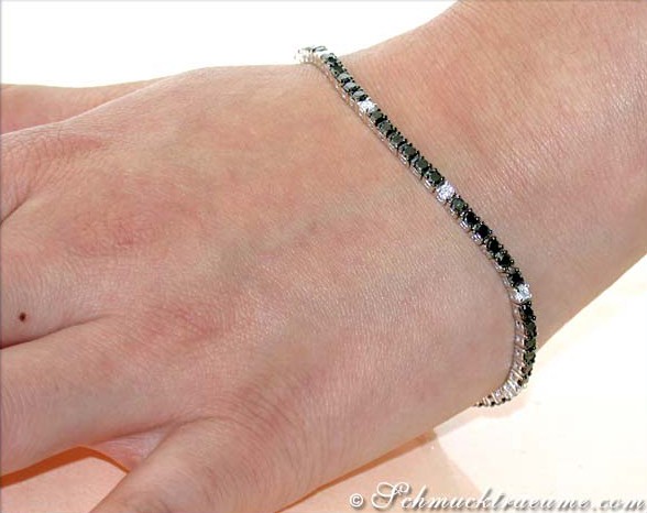 Schwarzes Diamant-Tennisarmband auf Hand, Detailaufnahme mit weißem Hintergrund