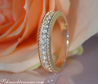 Goldener Diamant-Ring mit Kordel-Design auf Rosenblüte