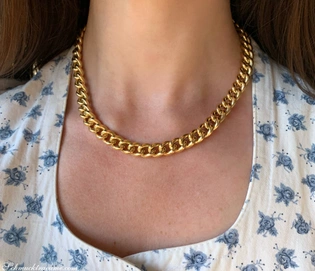 Goldene Panzerkette auf Hals von Frau in Blumenkleid