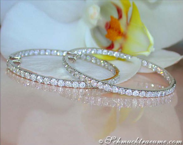 Brillanten Creolen in Weißgold 750, Detailaufnahme mit Orchidee im Hintergrund