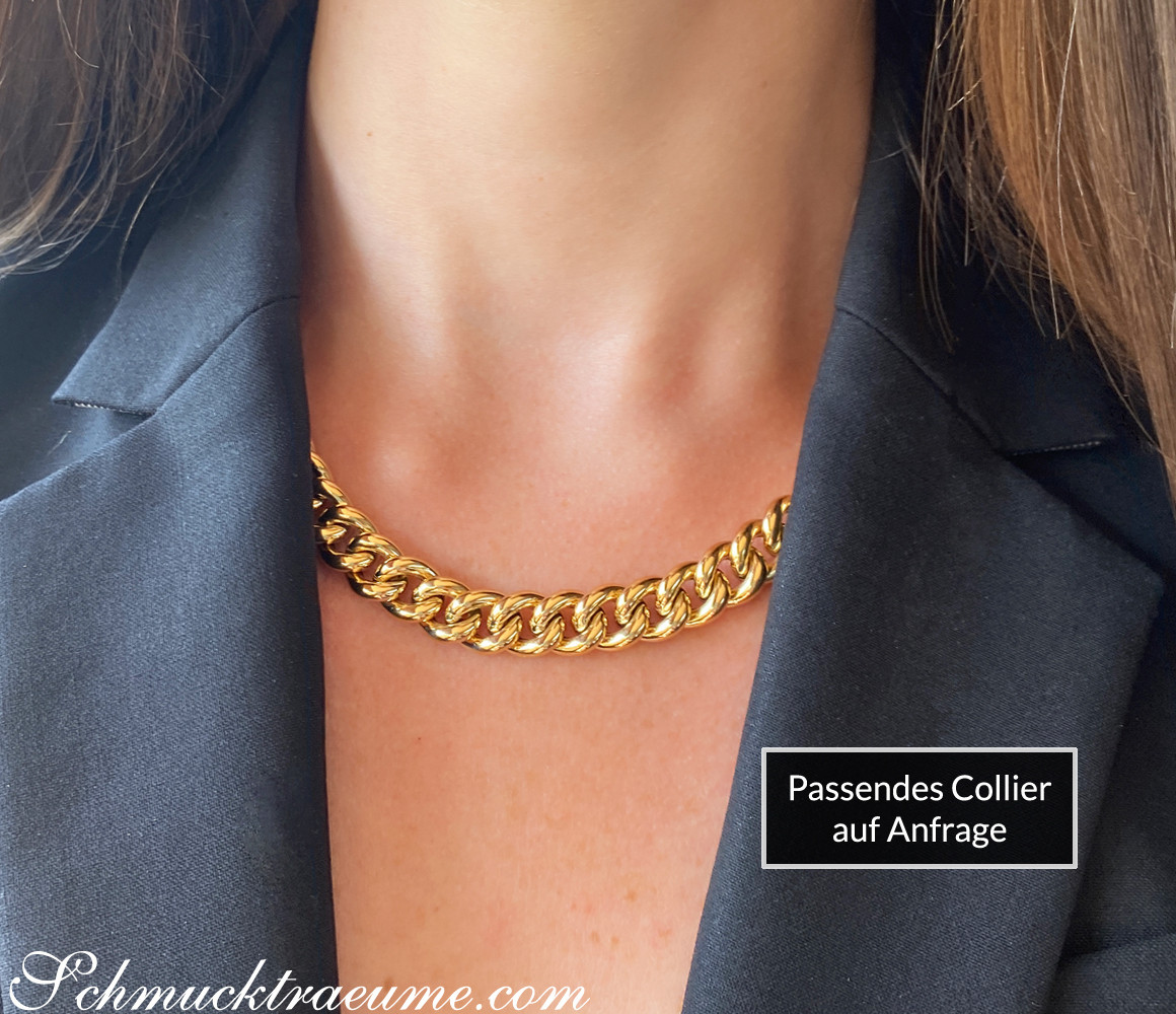 Goldene Kette am Hals in schwarzer Jacke, Detailaufnahme.