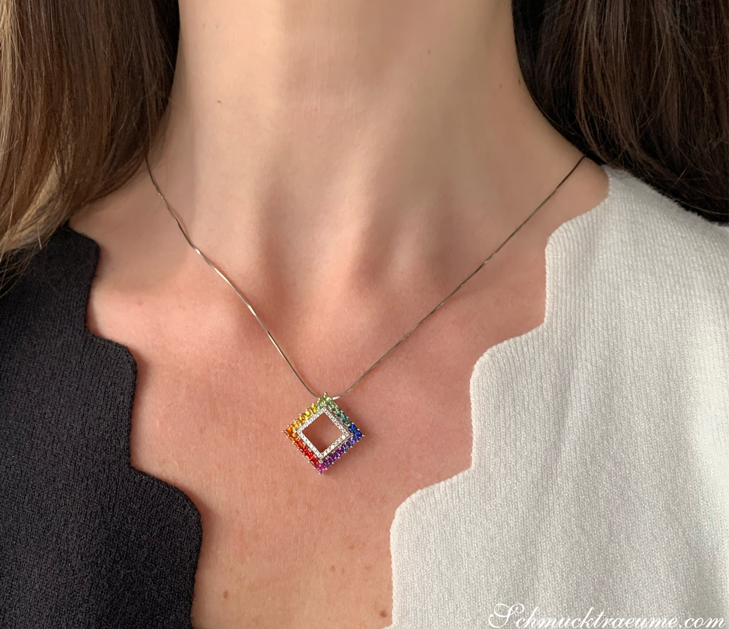 Weiblicher Hals mit elegantem Regenbogen-Saphir-Anhänger in Weißgold, detailreich verziert