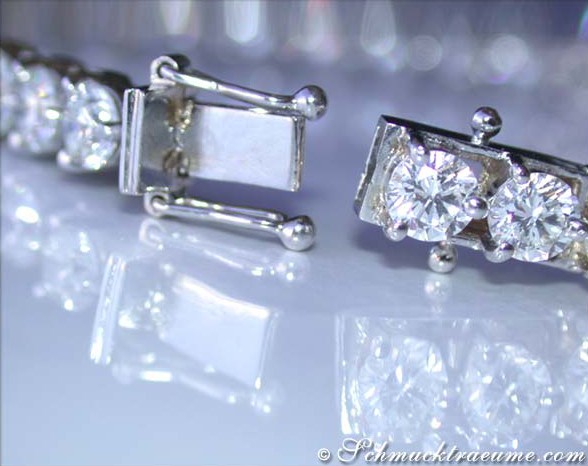 Weißgold-Tennisarmband mit funkelnden Diamanten auf glänzender Oberfläche