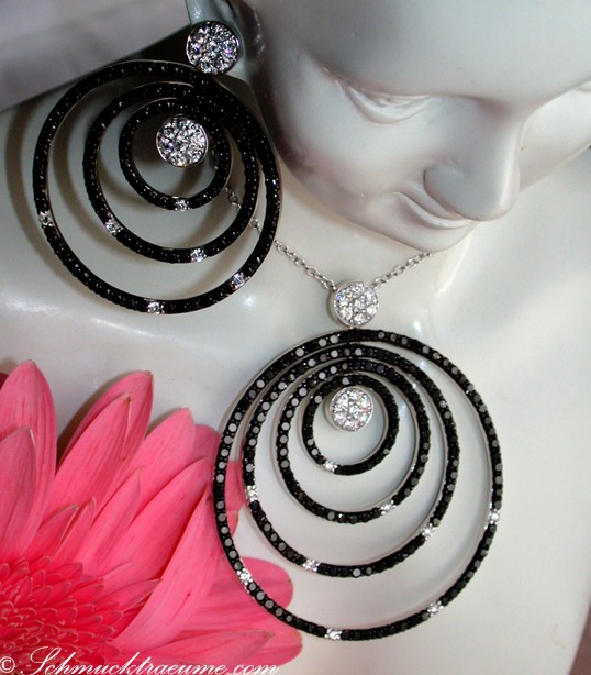 Schwarze Diamant-Halskette mit spiralförmigen Details auf weißem Mannequin, rosa Blume im Vordergrund