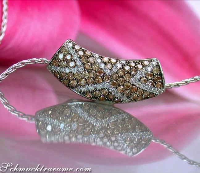 Weißgold-Anhänger mit cognac-braunen und weißen Brillanten, Detailaufnahme, rosafarbener Hintergrund. Weißgold-Anhänger mit cognac-braunen und weißen Brillanten, Detailaufnahme, rosafarbener Hintergrund.