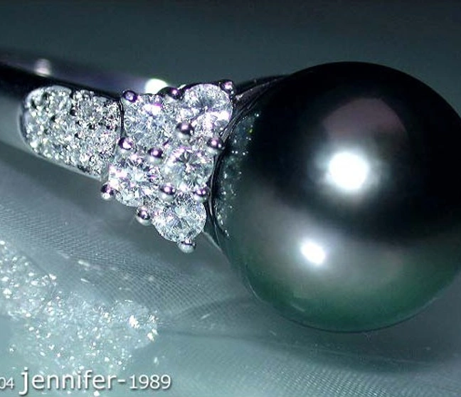 Weißgoldring mit Tahitiperle und Diamanten, Detailaufnahme, glänzende Oberfläche, elegante Schmuckkombination. Weißgoldring mit Tahitiperle und Diamanten, Detailaufnahme, glänzende Oberfläche, elegante Schmuckkombination.
