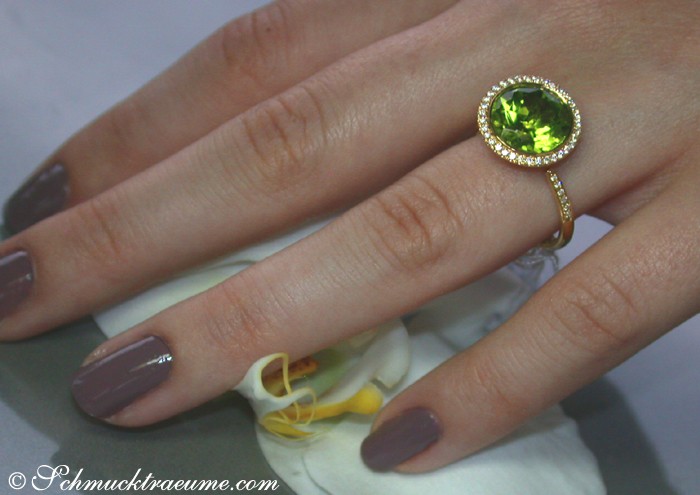 Peridot-Ring mit Diamanten in Gelbgold 750, Detailaufnahme auf Finger, elegantes Design.