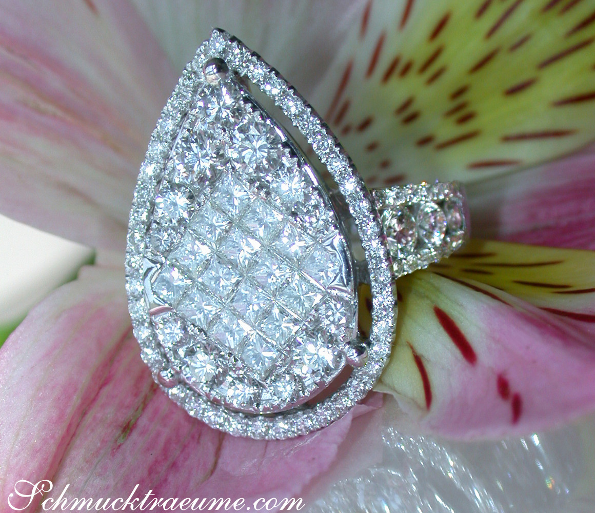 Detailaufnahme eines Diamant-Tropfenrings mit Princess- & Brillantschliff, auf Blüte abgestellt.