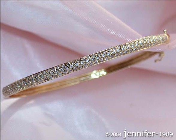 Goldener Diamantenarmreif auf rosa Stoff, Detailaufnahme