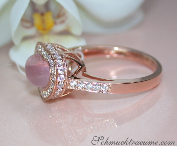 Rosenquarz Herz Ring mit Brillanten in Roségold, Detailaufnahme, weißer Hintergrund, Orchideenblüte.