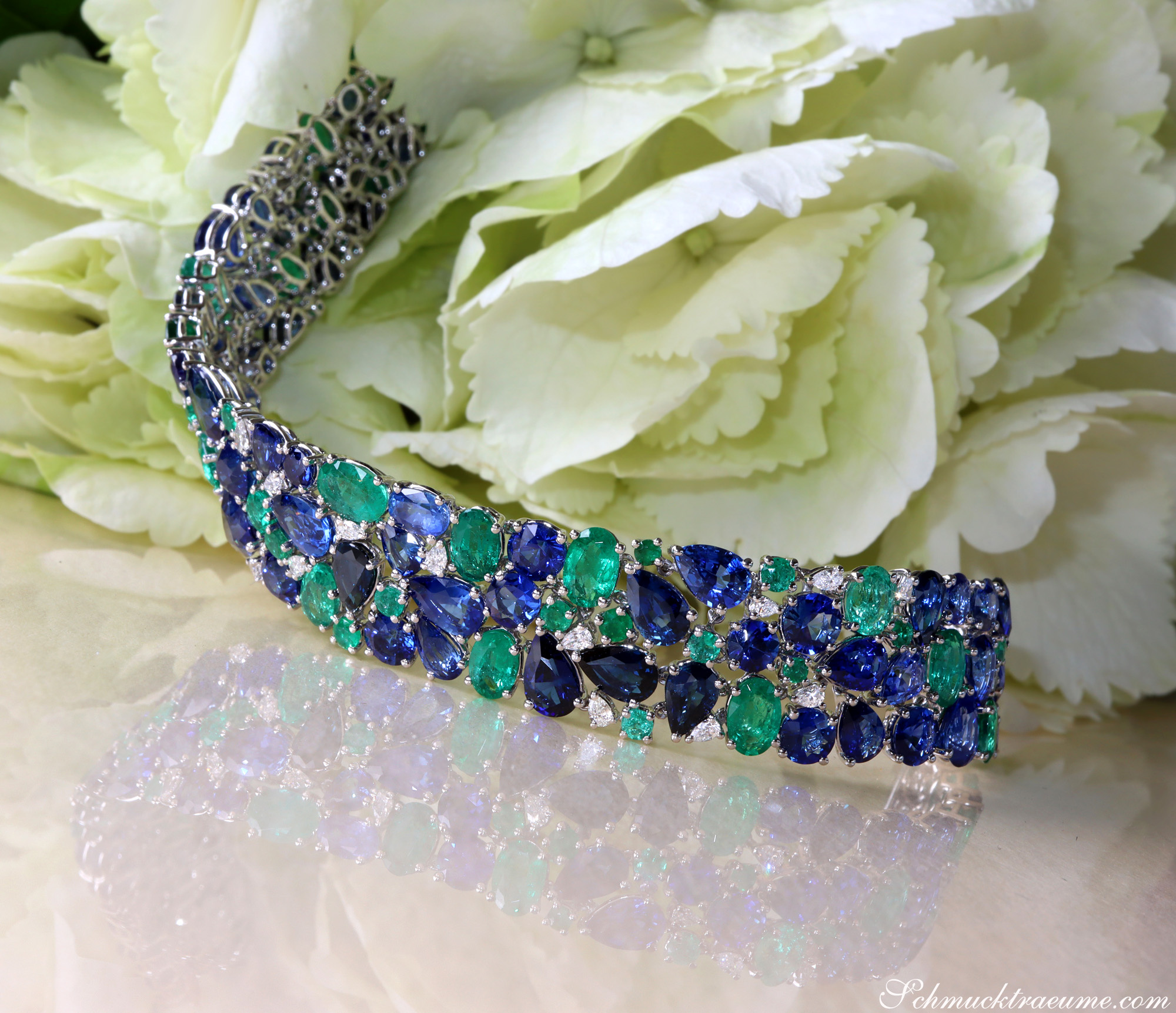 Saphir-Armband mit Smaragden und Diamanten auf Blütenhintergrund
