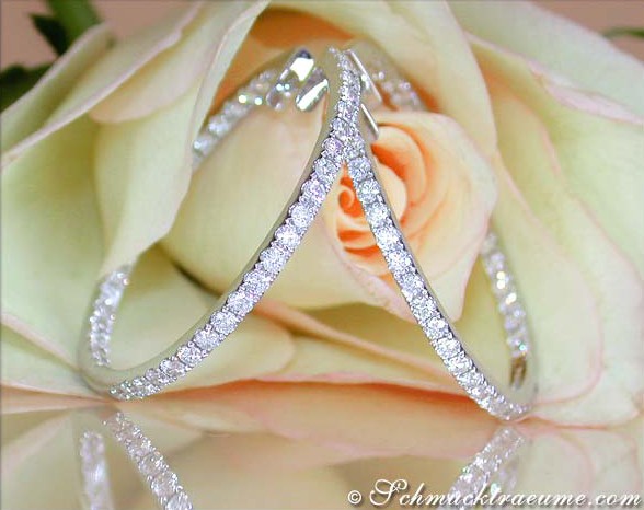 Detailansicht von Creolen mit Diamanten auf Rosenblüte, elegant und klassisch.