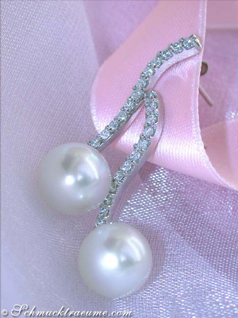 Schwungvolle Südseeperlen Ohrstecker mit Brillanten auf weißem Hintergrund