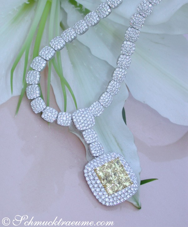 Blumiger Hintergrund mit detailreichem Brillanten-Collier und gelben Diamant-Herzanhänger